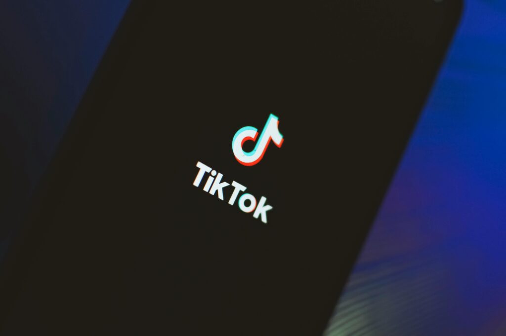 A close-up view of the TikTok app logo illuminated on a smartphone screen.